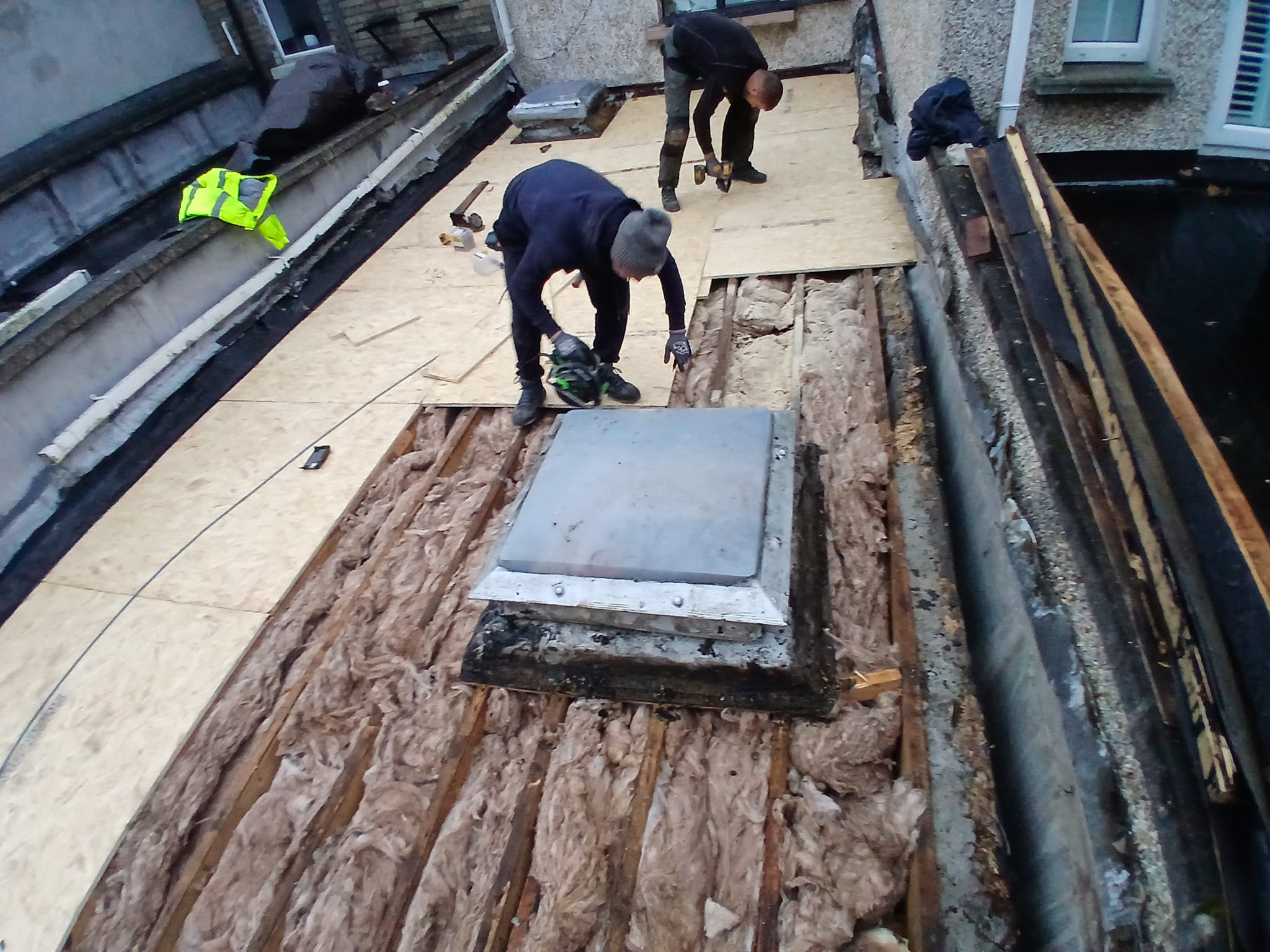 Two Dublin roofers fixing a flat roof.