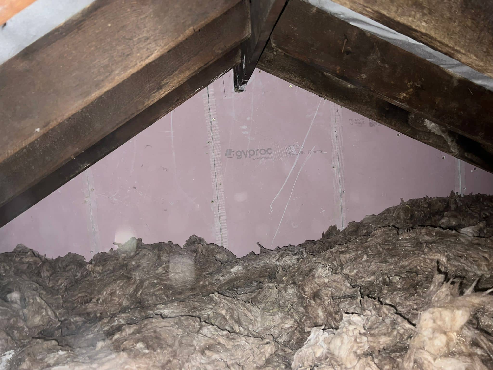 insulation board being installed over soft wool insulation.