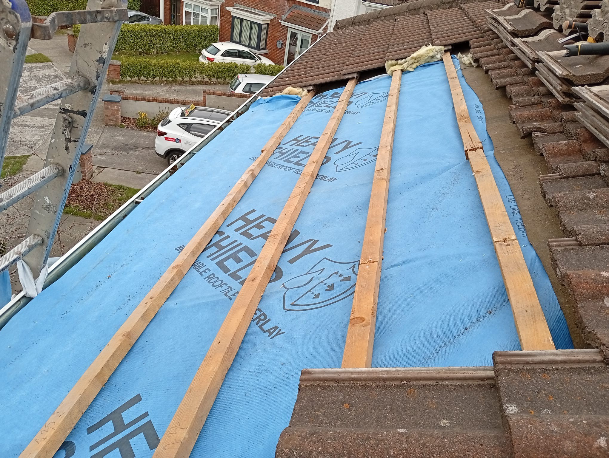 Tiles being removed from a roof in Dublin and exposing the membrane beneath