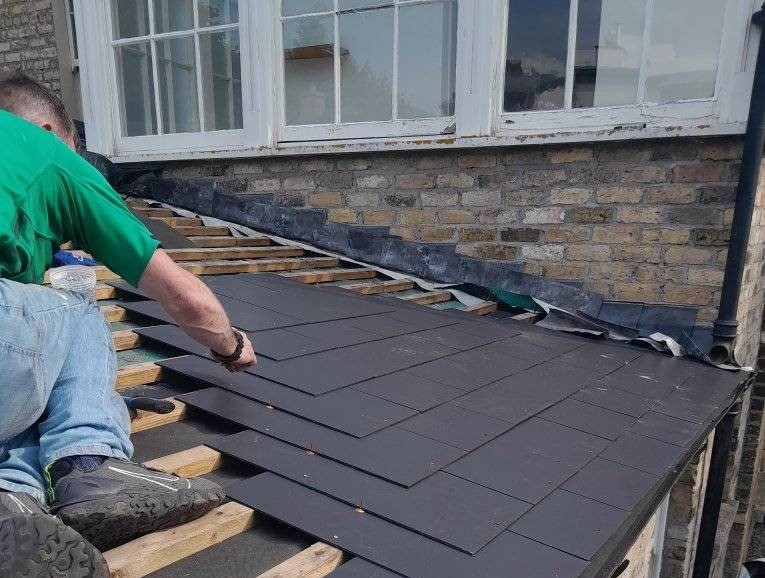 member of the modern roofing team installing tiles on a roof in Dublin