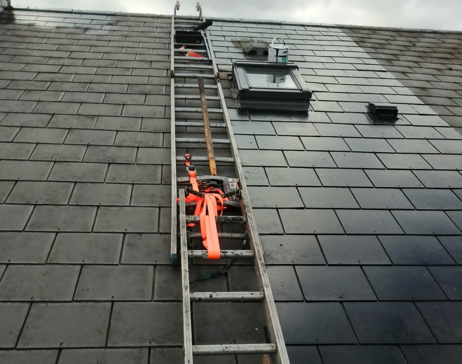Velux Window on a roof with a ladder next to it.